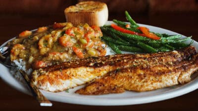 Blackened Gulf Redfish Etouffee served with rice and vegetables