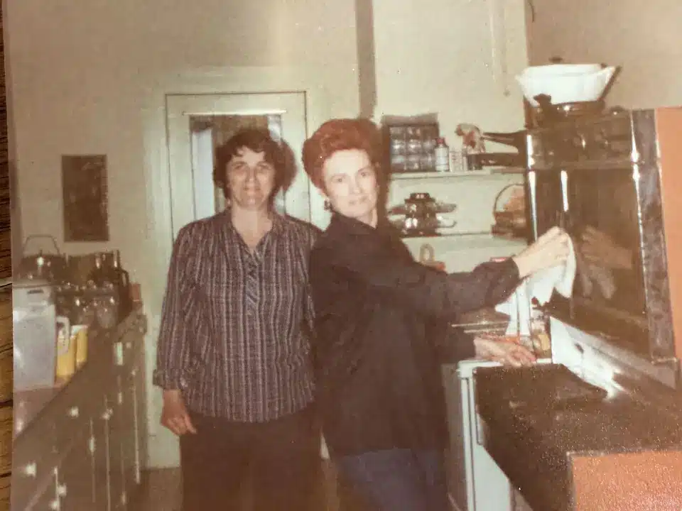 Two women in a kitchen setting.